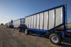 Two sets of blue Wesco trailers on a road