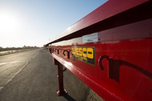 red wesco flatbed on a road at sunrise