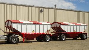 red and white hopper trailer in front of a building