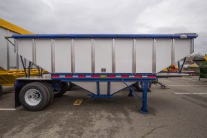 blue and white hopper trailer in a parking lot